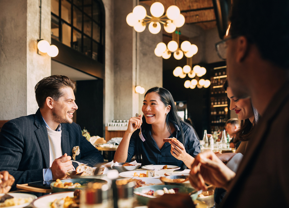 Friends dining in a restaurant laughing and having a good time.