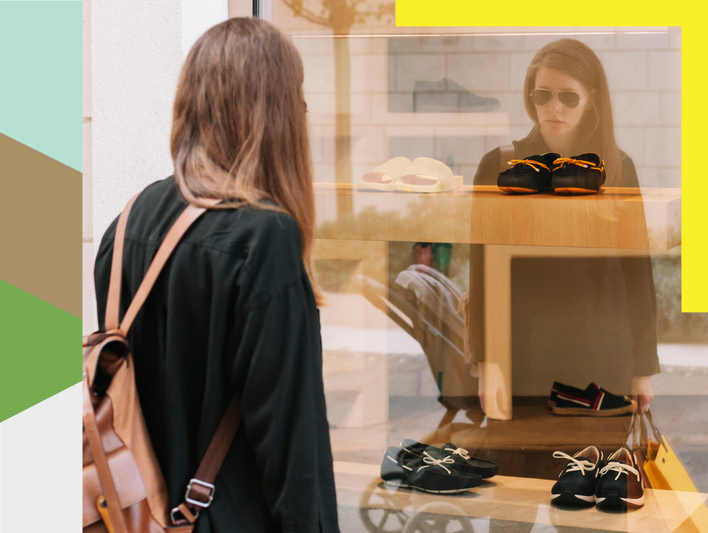 Woman looking inside shoe store shop windows.
